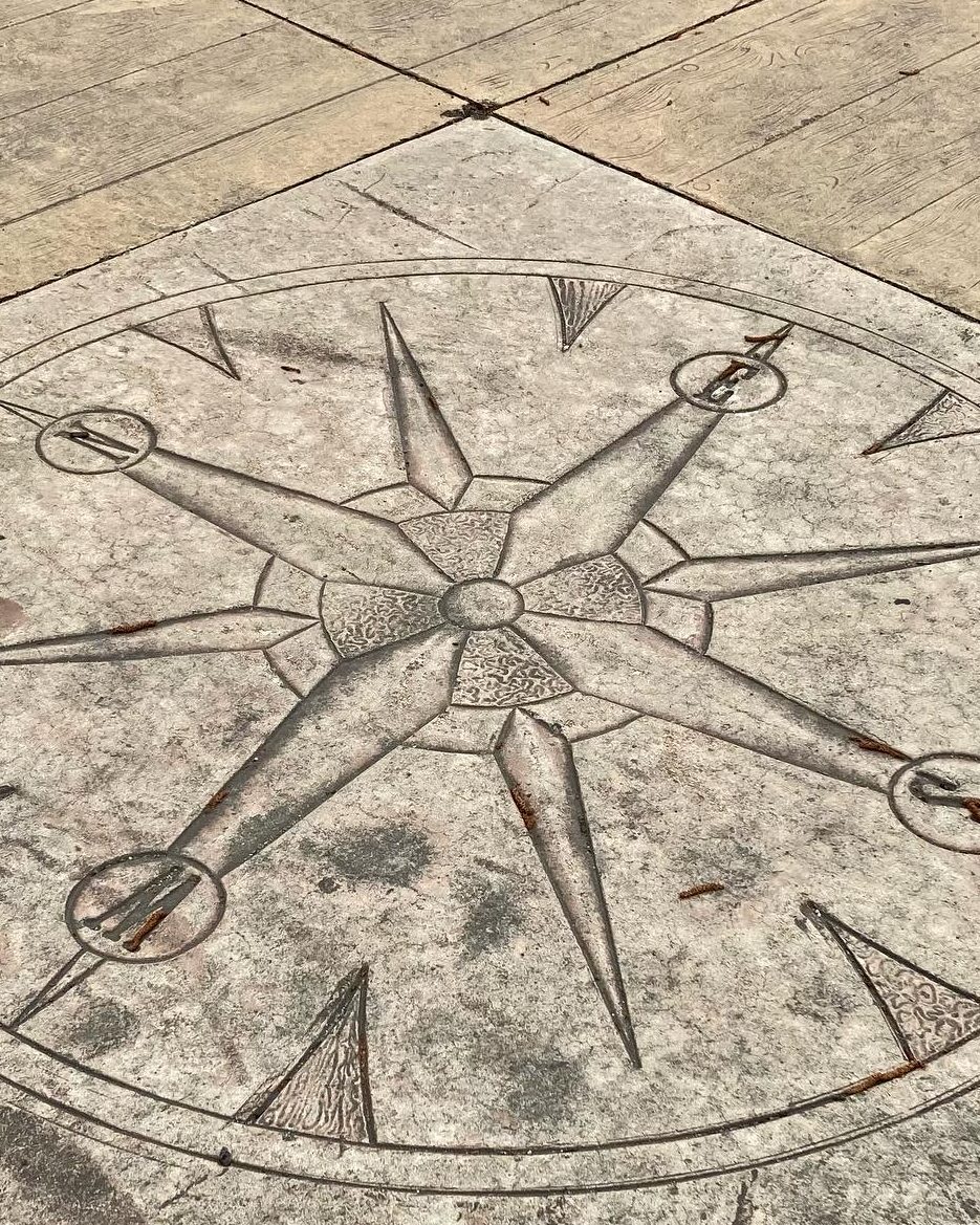 Picture of a large compass, embedded in the cement of the sidewalk in Salem, MA.